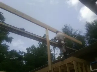 Carpenter setting a ridge beam over a new addition frame — Ice Dam Removal by Roofing Brothers in New Rochelle