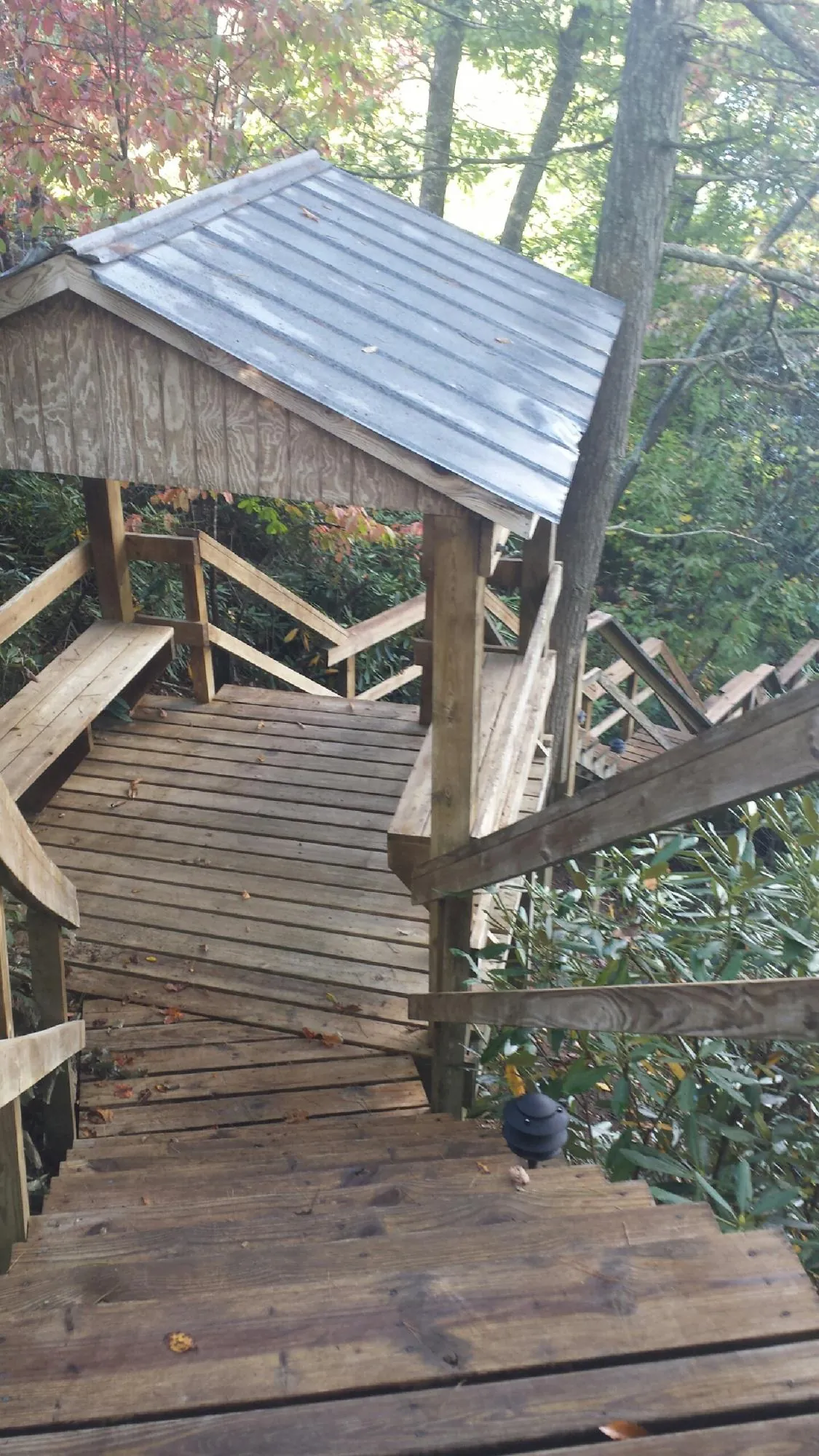 Metal roofed shelter over wooden steps on a wooded walkway — Skylight Repair & Installation work by our crew in New Rochelle