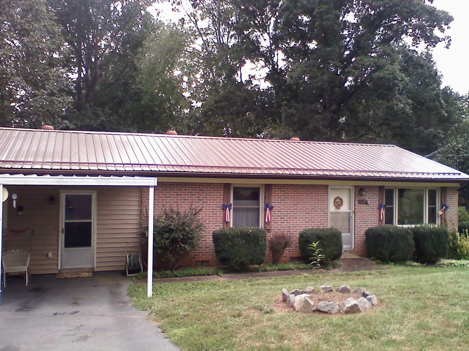 Bronze metal roof and carport on a brick ranch home — Roof Repair work by our crew in New Rochelle