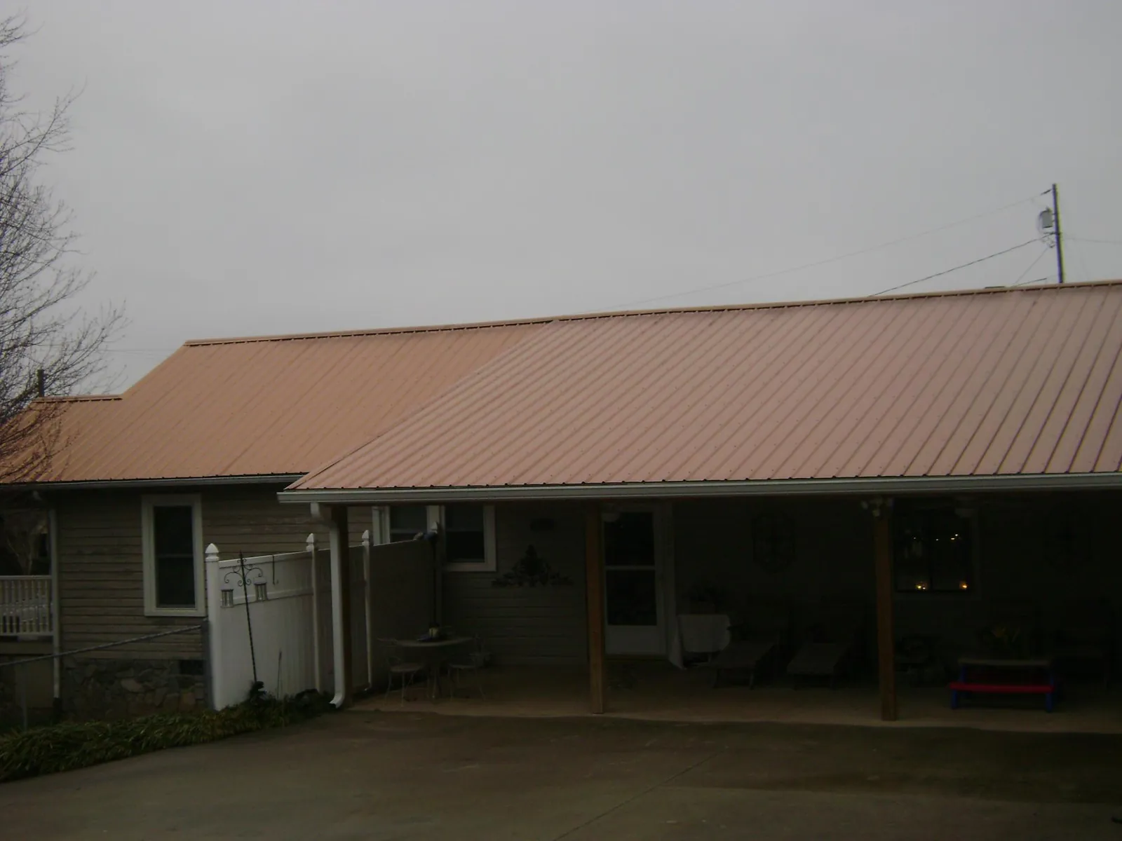 Copper toned metal roof over a wide covered patio in New Rochelle